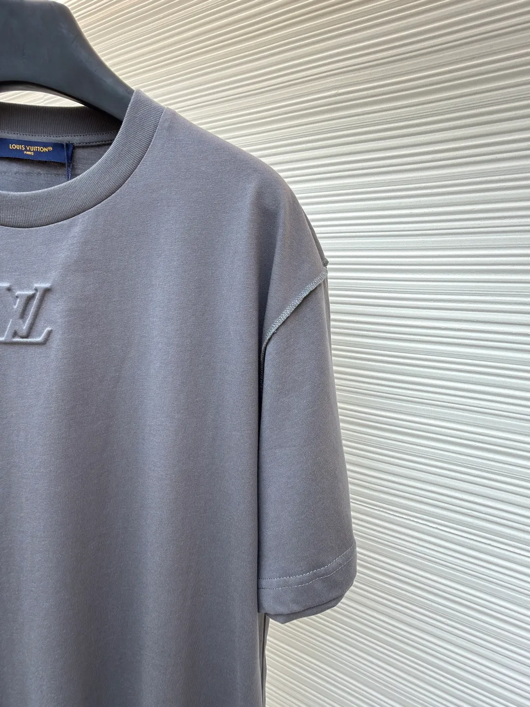 LOUIS VUITTON Concave embossed round neck short sleeves ●Original version: Purchased and developed in 5010 ●Item number: 1681360-A00 ●Fabric: plain knitted fabric ●Technology: embossed embossed production ●Color: gray ●Version: fitted version ●Weight: about 205 grams ●Size: High-count combed cotton yarn eliminates most of the short hairiness through compact spinning process, making the yarn smoother and stronger. The woven fabric structure is extremely dense, flat and soft, with excellent anti-pilling ability and durability, while retaining the natural advantages of pure cotton, which is breathable and skin-friendly. The neckline is made of 32S 1x1 rib with a weight of 300g. The finer yarn count creates a more delicate and tight thread, which provides better elasticity and deformation resistance than ordinary ribs, ensuring that the neckline can still remain stiff after being put on and taken off many times. It contains an innovative process of silicone lining. The concave and convex embossing process is heated and shaped by the upper and lower dies. The rollers press the fabric at a certain temperature, and the three-dimensional hierarchical convex surface is produced through mechanical embossing. This makes the embroidered patterns not only three-dimensional and full, but also uniquely soft and elastic to the touch, which is completely different from traditional stiff embroidery. The support of silicone also ensures that the pattern is not prone to wrinkles and deformation after washing, achieving a combination of visual novelty and process durability. The overall wiring is straight and delicate, the fabric is comfortable and soft, and the color is consistent without color difference. It can be matched with the same style to create a fashionable look and control various occasions. Customized accessories, complete with three standards, same style for men and women!